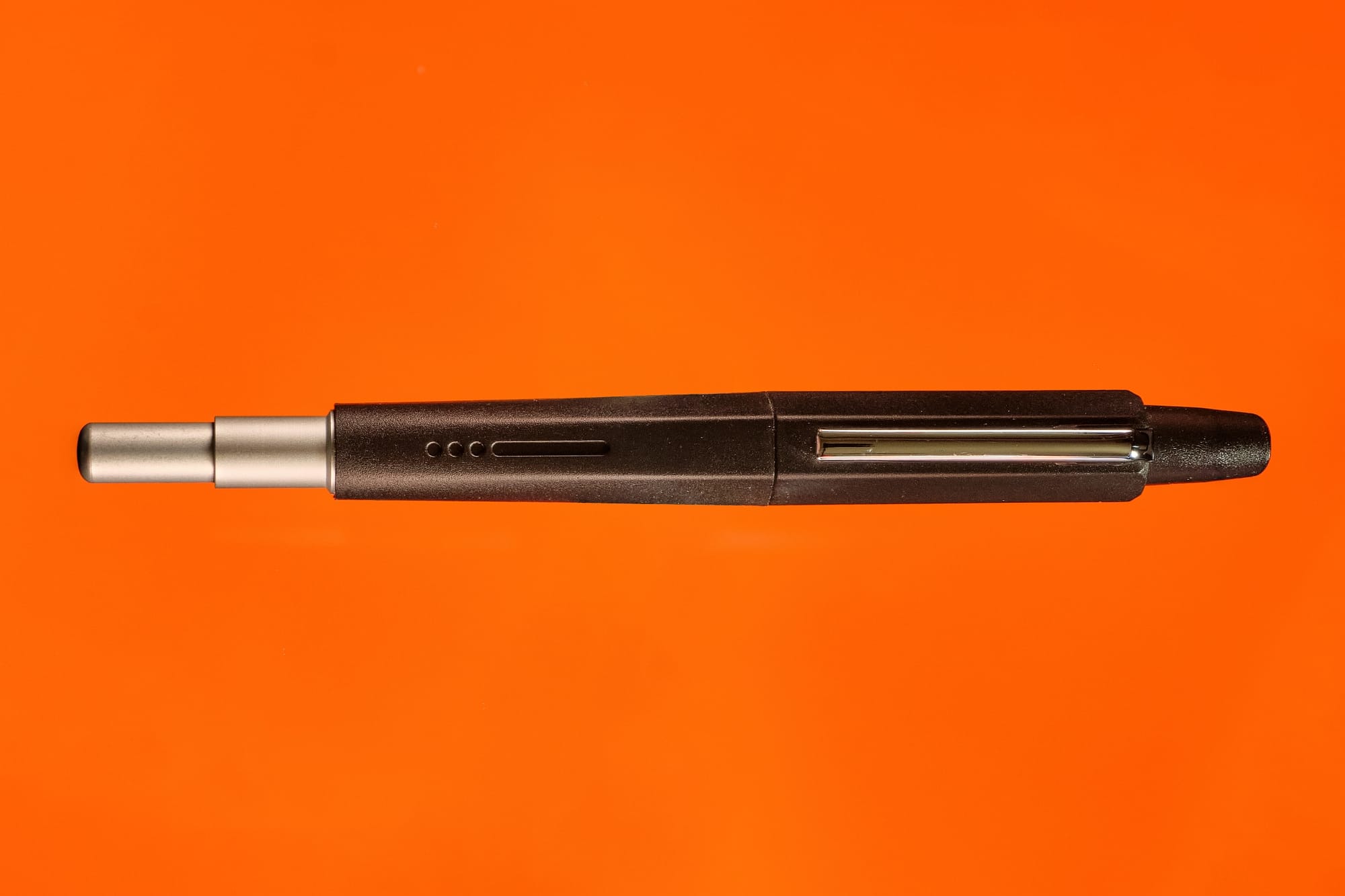Photo of the Endless Creator retractable fountain pen on an orange background