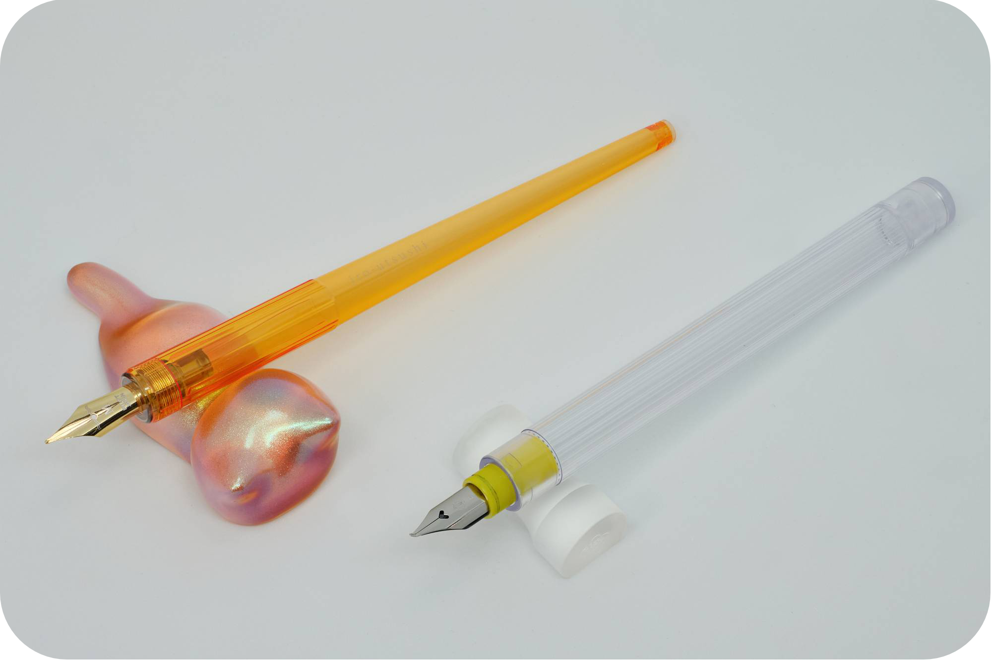 Photo of 2 dip pens (Pilot Iro-Utsushi & Sailor Hocoro) resting on pen rests on a white background