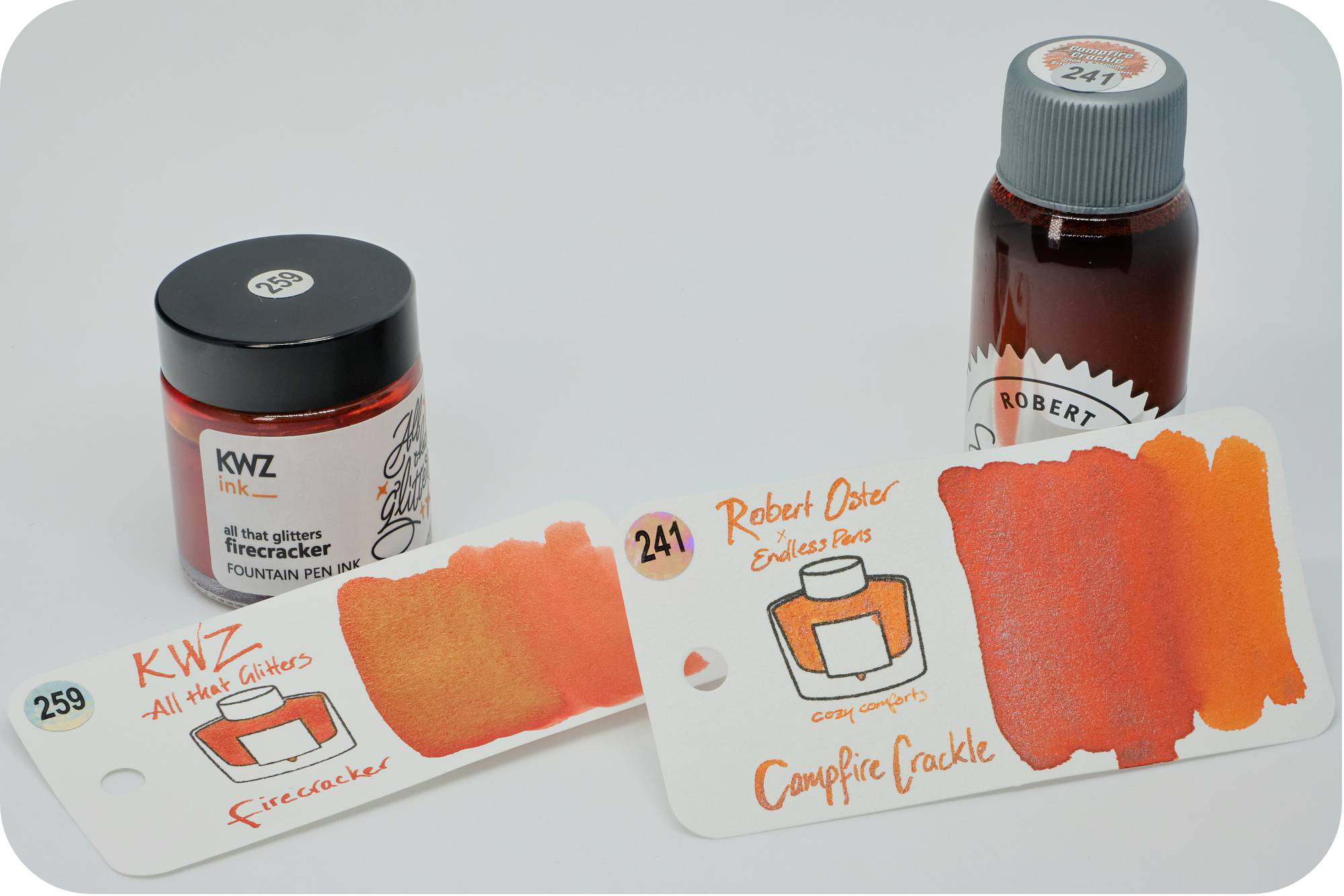 A photo of KWZ Firecracker & Robert Oster Campfire Crackle bottles behind their respective swatches on a white background